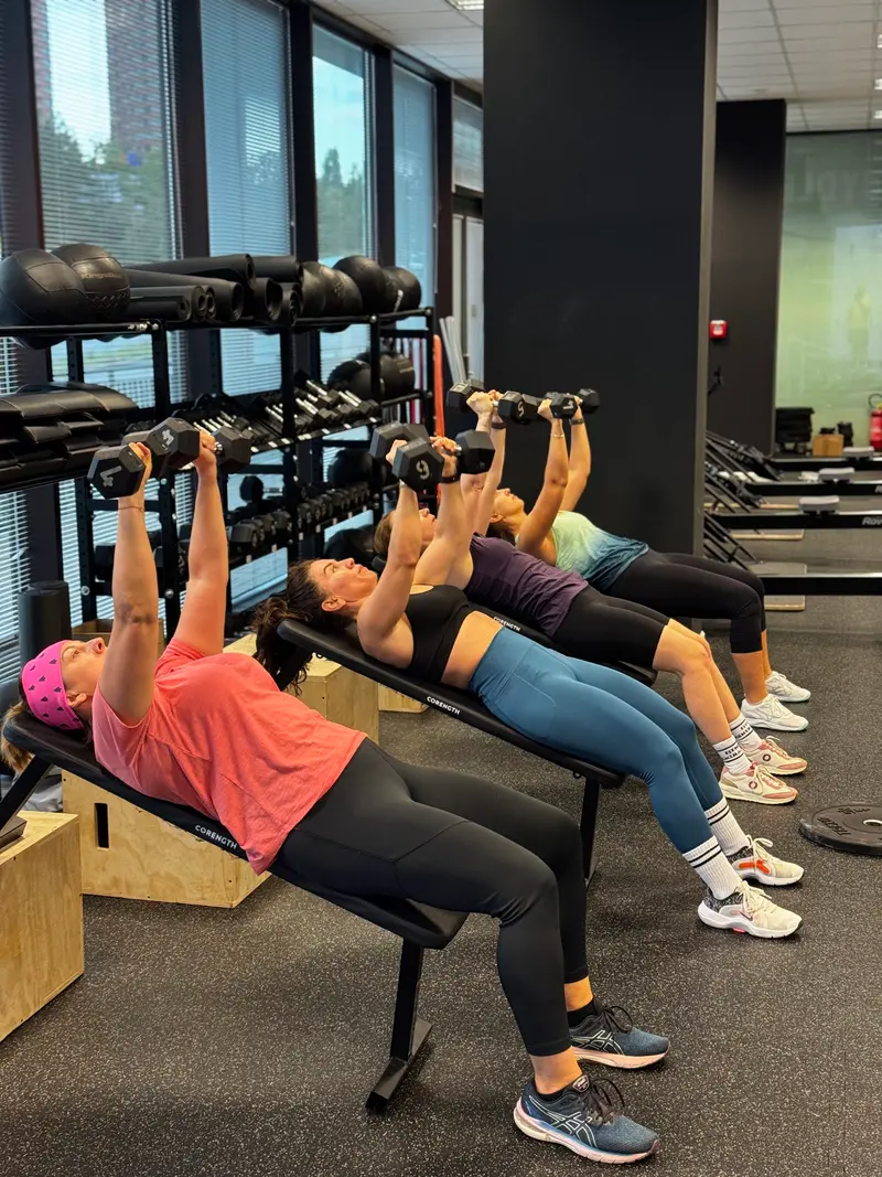 Skupinová lekce s tlaky jednoruček na lavičkách ve Fitness Central Park